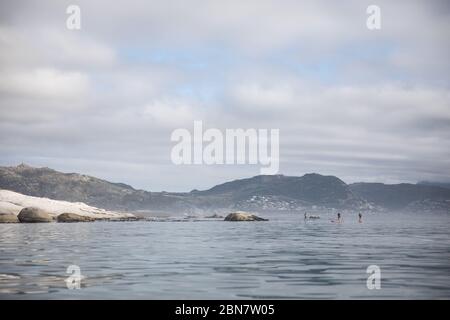 The scenic False Bay coast around Simon's Town on the Cape Peninsula, Cape Town, Western Cape, South Africa is popular among stand up paddle boarders Stock Photo