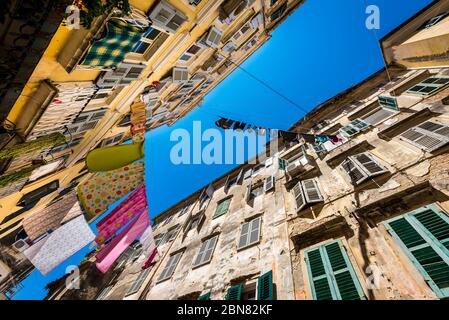 Colourful washing hanging out to dry between buildings in Corfu, Greece Stock Photo