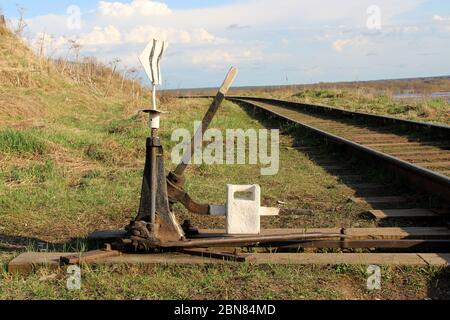 Railway arrow in black with a lever and pointer in Russia. The device for the transfer of rails at intersections for trains. Technical element of the railway industry. Stock Photo