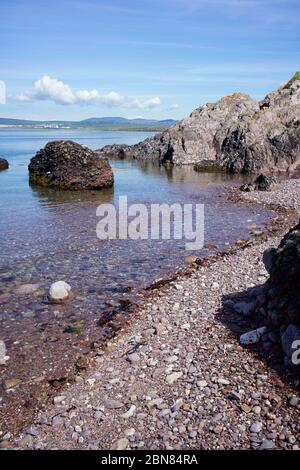 View across Castletown Bay viewed from Langness peninsular with rocks and beach in foreground Stock Photo