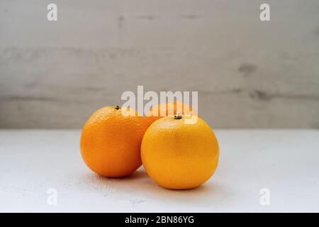 Three Oranges On A Wooden Table Stock Photo
