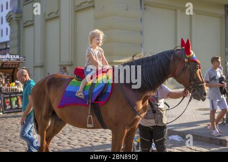 Odessa, Ukraine. July 22th 2018. Horse decked in pride colors. Horse riding - little girl is riding a horse. Stock Photo