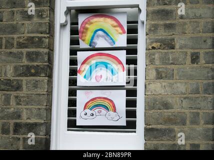 WIMBLEDON LONDON, 13 May 2020. UK. Rainbow drawings (rainbow a symbol of hope and peace) decorating a house window in Wimbledon as a show of support for the NHS (National Health Service) and all essential workers during the Coronavirus pandemic lockdown. Credit: amer ghazzal/Alamy Live News