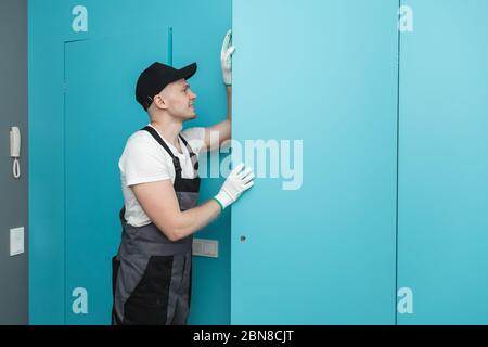 Working male fitter installs hidden invisible installation doors for painting Stock Photo