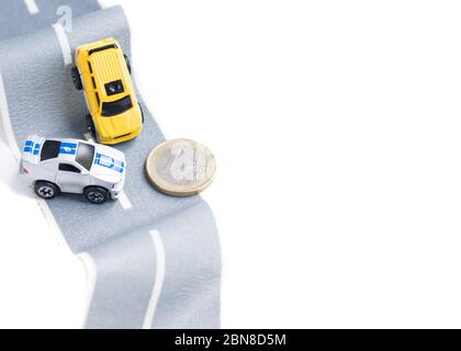 Cars accident on rough road. Expensive insurance. Incident. Toy models and coin 1 euro on duct tape. Slippery or rough road. Insurance. Incident Stock Photo