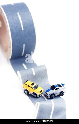 Cars accident on rough road. Two toy models on duct tape. Slippery or rough road. Insurance. Incident Stock Photo