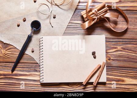 ink pen, craft notebook and cinnamon on the wooden desk Stock Photo