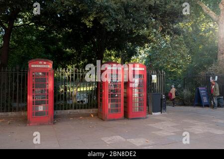 Three iconic British red telephone booths situated outside of Russel Square, London, England Stock Photo