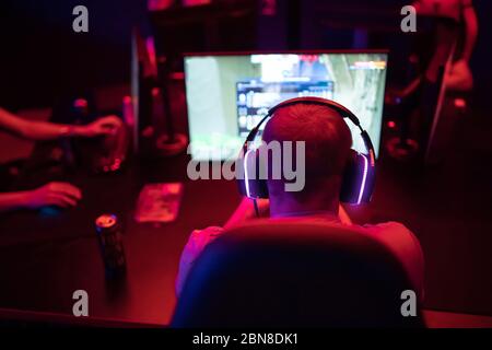 Professional cyber gamer studio room with personal computer armchair, keyboard for stream in neon color blur background. Soft focus Stock Photo