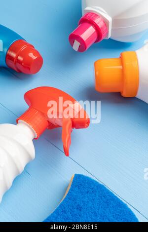 Cleaning and washing products in plastic bottles with bright covers on a wooden light blue background with a sponge Stock Photo