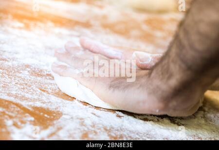 Male hands making dough on the table in the kitchen at home Stock Photo