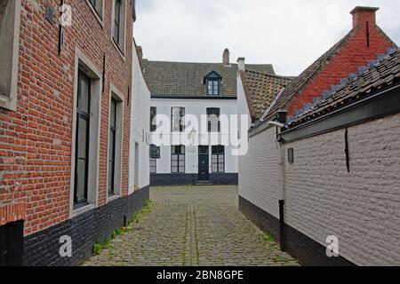 Cobblestone streets with small cosy white painted brick houses of the Holy corner or Old Saint Elisabeth beguinage, Ghent, Belgium Stock Photo