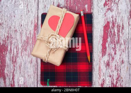 Handmade crafted paper gift boxes with notepad on wooden background  Stock Photo