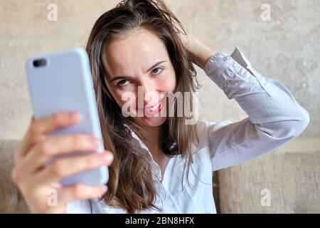 Drunk girl with smeared lipstick makes selfie photo. Close up. Stock Photo