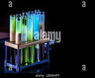 Cocktails in test tubes - creative alcohol bar drinks. Rainbow liqhuids in tubes. Copy space. Stock Photo
