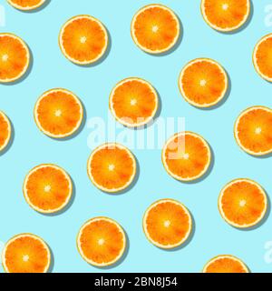 Seamless orange fruit pattern on blue background. Colorful fresh citrus slice wallpaper. Creative color, summer friuts concept. Minimal style. Stock Photo