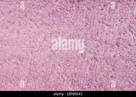 Pink fleecy synthetic fabric textile background. Soft plush fluffy cloth texture. Fuzzy pastel material for winter clothing, baby toys, and home texti Stock Photo