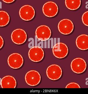 Colorful fresh grapefruit citrus slice seamless pattern. Fruits on bordo background. Creative color, summer friuts concept. Minimal style. Stock Photo