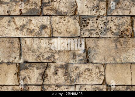 Seamless texture brick wall background. Pattern of stacked stone wall texture. Stones wall with rough surface. Uneven sandstone tile for wall surface. Stock Photo