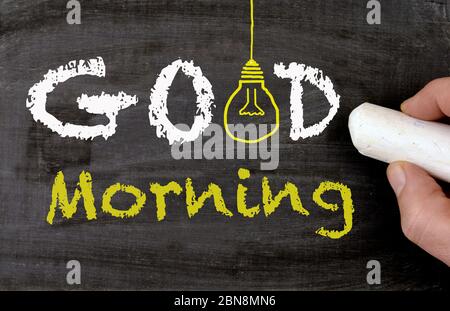 Good morning chalkboard, lightbulb and a hand Stock Photo