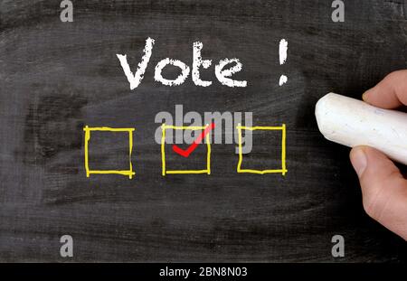 Blackboard with vote text and checkbox and hand are voting Stock Photo
