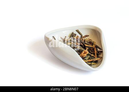 A pile of dried rhododendron Adamsia in a white bowl cha Hae, Sagan daily for tea. Isolated on a white background close up Stock Photo