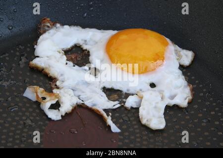 Fried egg in a pan. Over easy egg. Well done fried eggs. Stock Photo