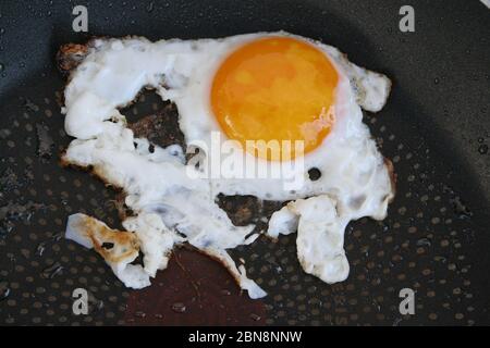 Fried egg in a pan. Over easy egg. Well done fried eggs. Stock Photo