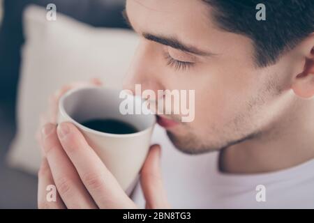 Cropped close-up portrait of his he nice attractive dreamy calm peaceful guy drinking cacao milk herbal useful tea herbs in living-room bedroom Stock Photo
