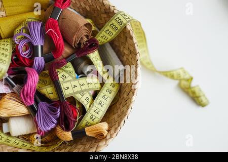 Close-up of colorful threads tape measure and other sewing items in the basket Stock Photo