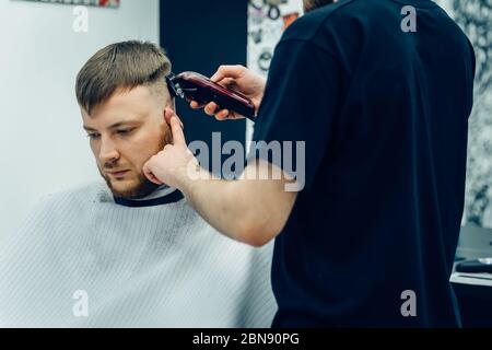 Male haircut with electric razor. Barber makes haircut for client at the  barber shop by using hairclipper. Man hairdressing with electric shaver  Stock Photo - Alamy