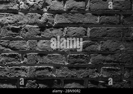 Black brick wall texture background. Pattern of weathered old cracked brickwall. Stacked stones wall rough surface. Obsolete grunge surface. Vintage w Stock Photo