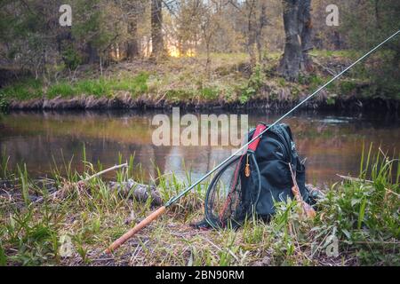 https://l450v.alamy.com/450v/2bn90rm/fishing-rod-backpack-and-fishing-gear-on-the-river-bank-tenkara-2bn90rm.jpg