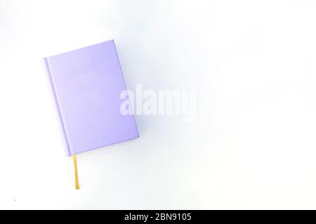 Purple notebook or book on the bright background with the yellow ribbon mockup Stock Photo
