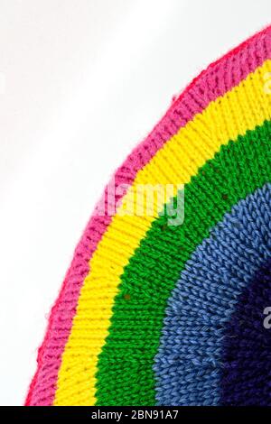 Close up of a knitted item in the shape of a rainbow, Space for copy top left. Stock Photo
