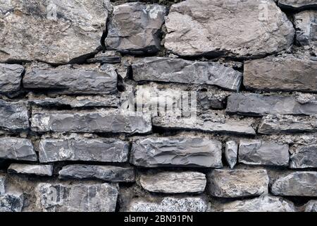 Grey masonry, stonework, brickwork texture. Concrete different gray stone surface with cement. Rock gloomy pattern background. Abstract damaged urban Stock Photo