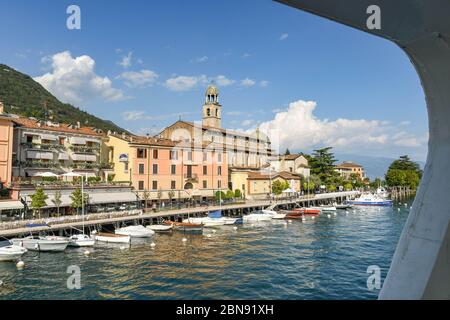 SALO, ITALY - SEPTEMBER 2018: Lakefront of the town of Salo on Lake Garda with view framed by the window of a ferry. Stock Photo