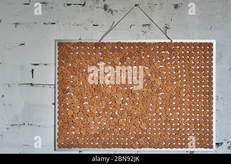 Homemade chopped wine cork note board on brick wall, selective focus Stock Photo