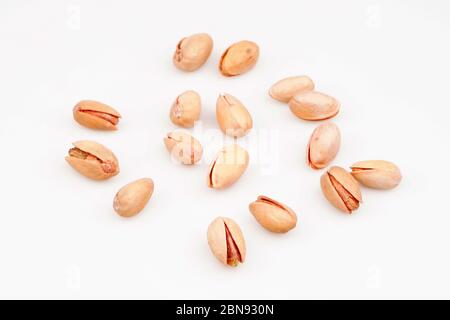 Organic pistachio nuts scattered on white background Stock Photo