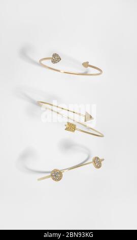 Top view of three different design golden bracelets on white background Stock Photo