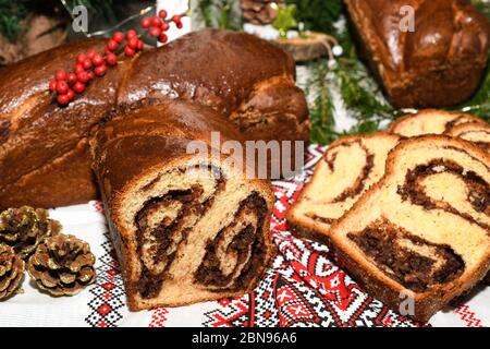 Closeup of slices of homemade traditional Romanian sweet bread named "cozonac", with cacao, raisins, various nuts and chocolate chips, ready to be eat Stock Photo
