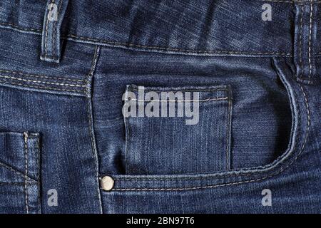 Close-up on a piece of denim trousers: seams, rivets and pockets. Stock Photo