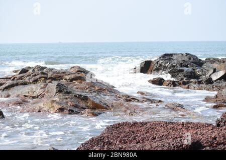 Sea waves hitting the rocks.Anjuna beach,Goa,India. Stock Photo