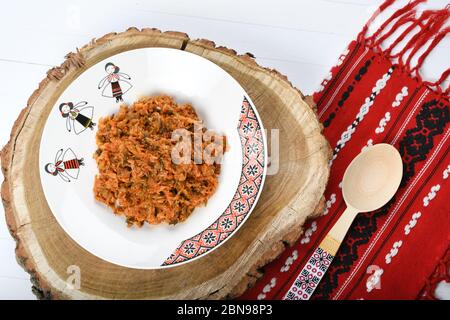 Stewed cabbage traditional Romanian dish, served in a traditional plate on a piece of wood and traditional red napkin Stock Photo
