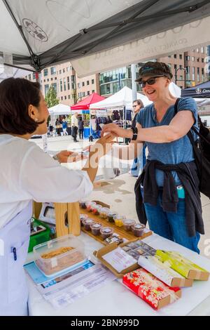 Woman buying artisan chocolates at Downtown Farmers Market, Queen Elizabeth Plaza, Vancouver, British Columbia, Canada. Stock Photo