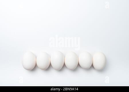 Six white chicken eggs in a row Stock Photo