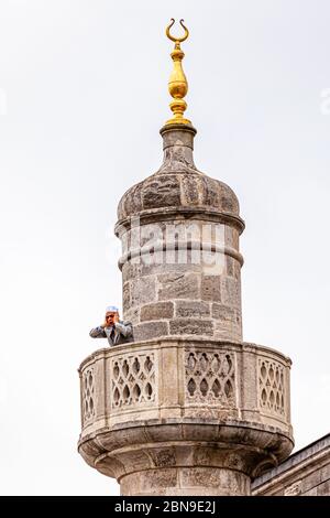 Muezzin singing from the minarett of Topkapi, Fatih, Istanbul, Turkey. Without loudspeakers and amplifiers. On the minaret in Topkapi Palace, the muezzin personally calls for prayer purely acoustically Stock Photo