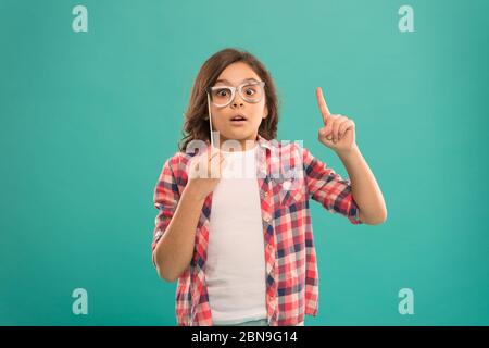 fully inspired child. school girl got an idea. childhood happiness. child in good and positive mood. looking smart in glasses. small girl inspired by casual fashion. happy kid in funny party glasses. Stock Photo