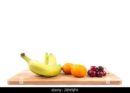 Bananas, tangerines and cherries on a white background. Various fruits Stock Photo