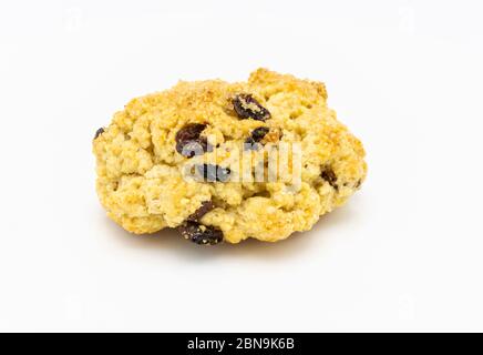 A single traditional delicious fresh golden home baked rock cake with raisins and brown sugar crystals viewed close up against a white background Stock Photo